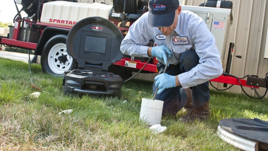 plumber with camera in sewer pipe