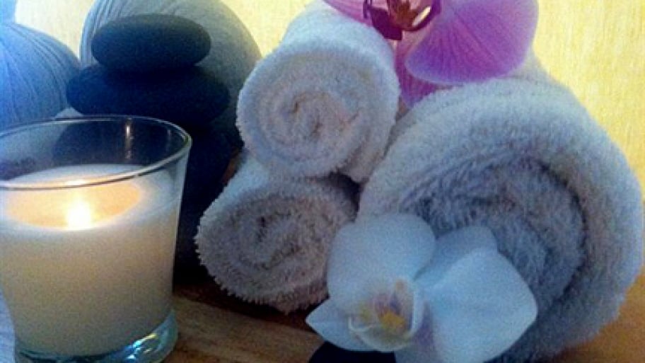 Shiatsu massage rolled towels, a candle, stones and other supplies for a Shiatsu massage s
