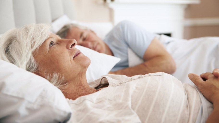 senior woman lying awake in bed