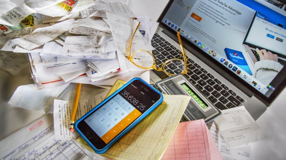 receipts, smartphone, pencl and a laptop