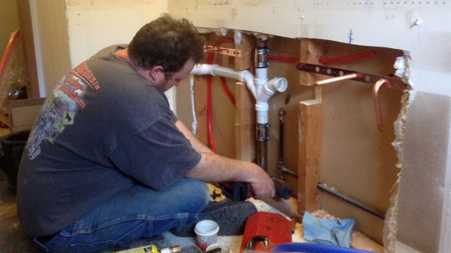 plumber working on kitchen remodeling project