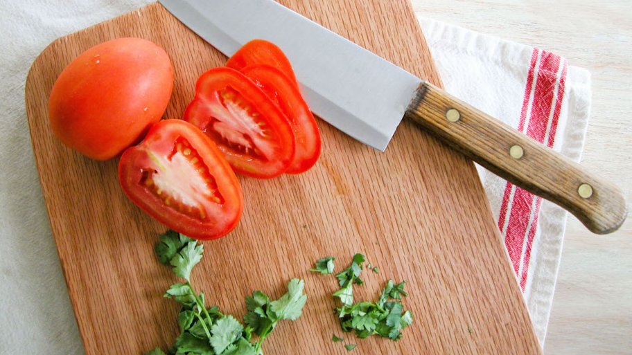 rustic cutting board with tomatoes and cilantro