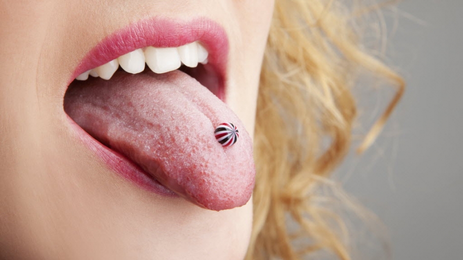 Woman sticks out pierced tongue.