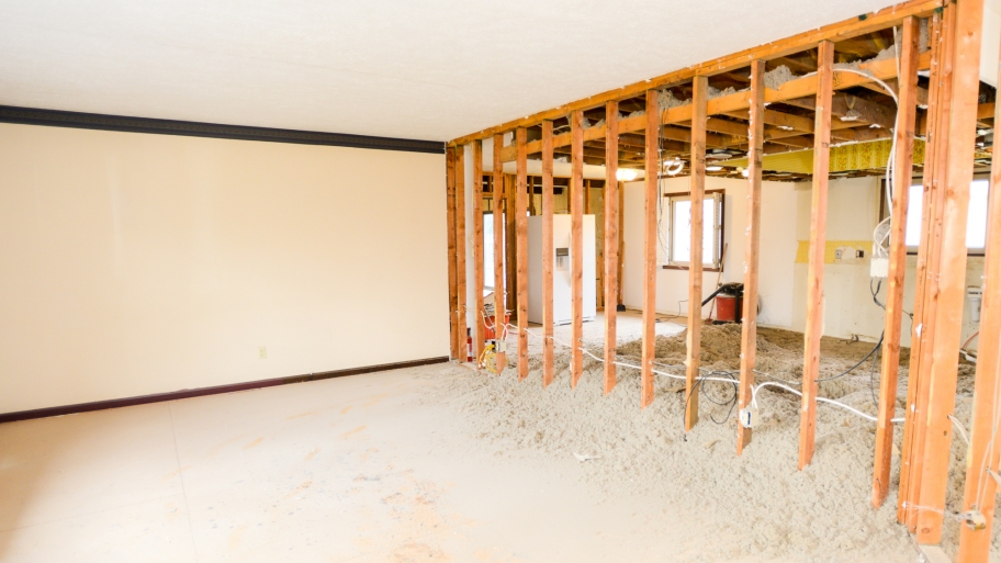 living room with one wall torn down to studs