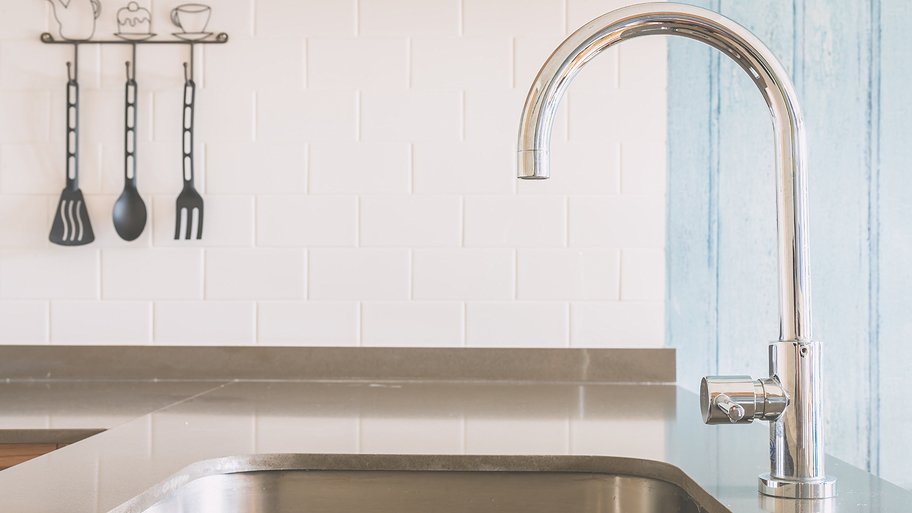 stainless steel faucet and sink with gray countertop