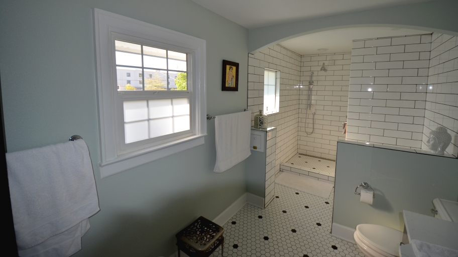 Spacious renovated bathroom with walk-in shower and white subway tile.