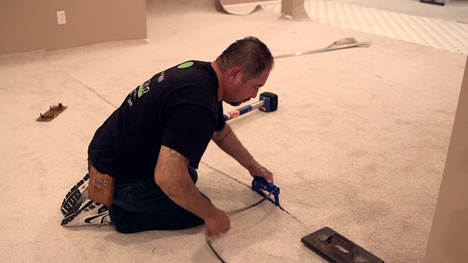 man installs carpet