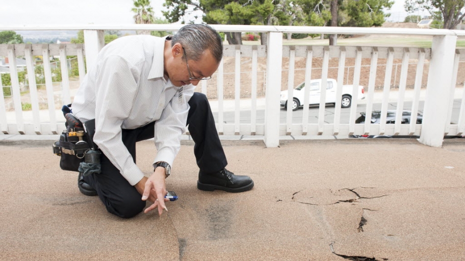 man inspecting a damaged deck