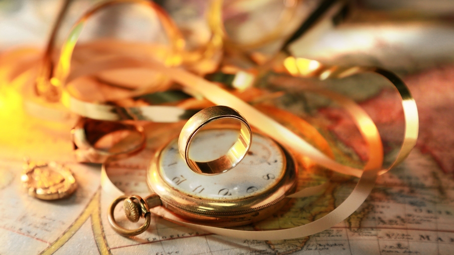 Gold ring on shiny pocket watch expensive jewelry