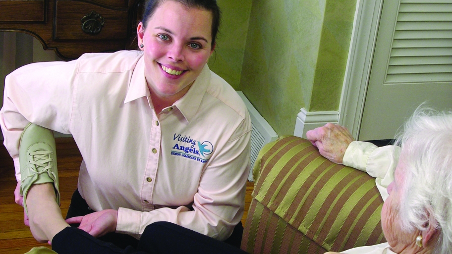 caregiver assisting elderly woman in home