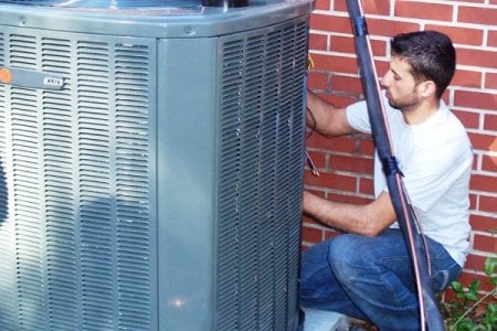 HVAC technician servicing air conditioner