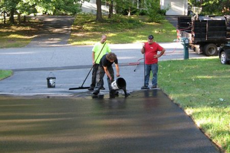 Should I Seal My Concrete Or Asphalt Driveway Angie S List Contractor Pouring Sealant On Asphalt Driveway