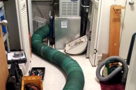 air duct cleaning in process with large green hose