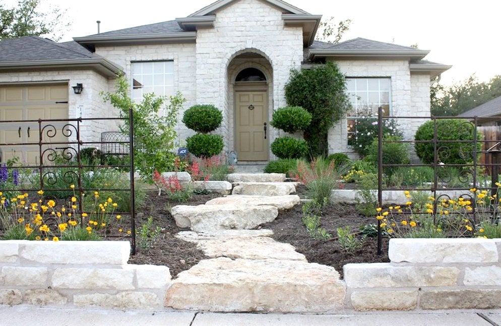house exterior with shrubs and stone walkway