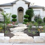 house exterior with shrubs and stone walkway