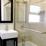 remodeled bathroom with glass shower doors and mirror