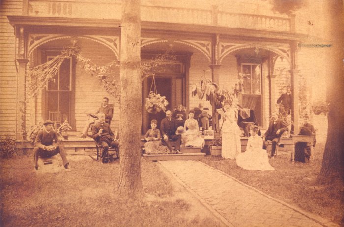 antique photo of a family in front of their home in the early 1900s
