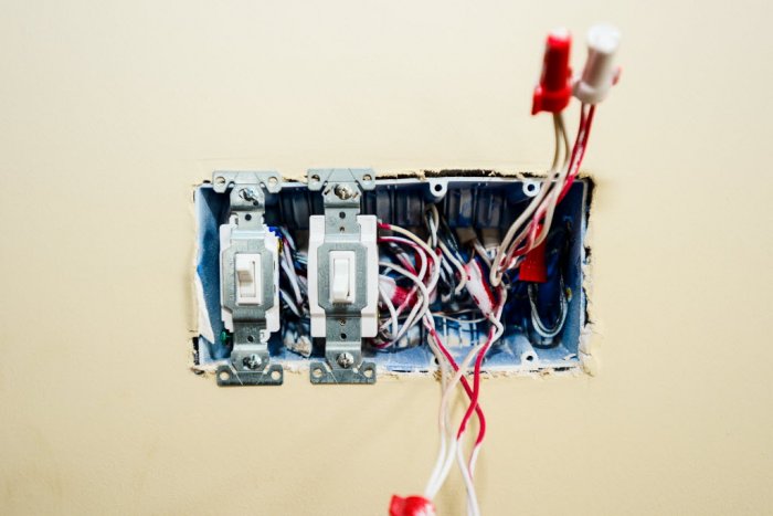 an open light switch panel with wires