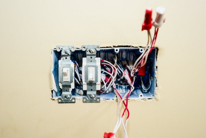 an open light switch panel with wires 