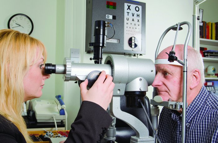 older man getting eye exam by female doctor