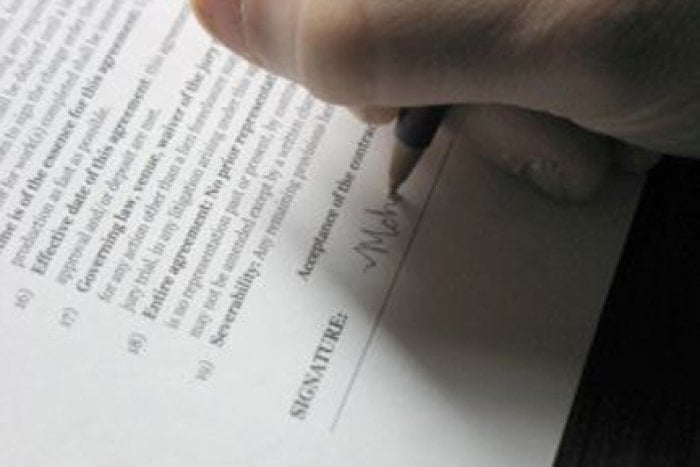 hand with pen signing contract