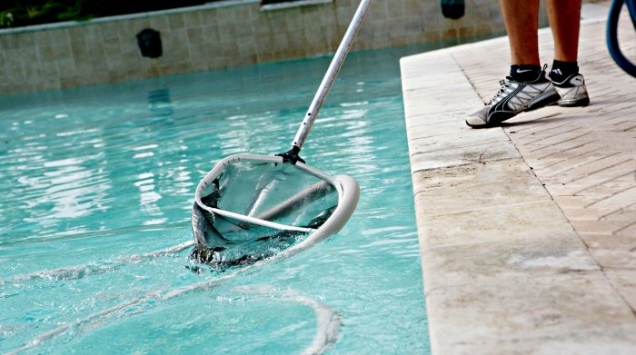 man cleaning pool