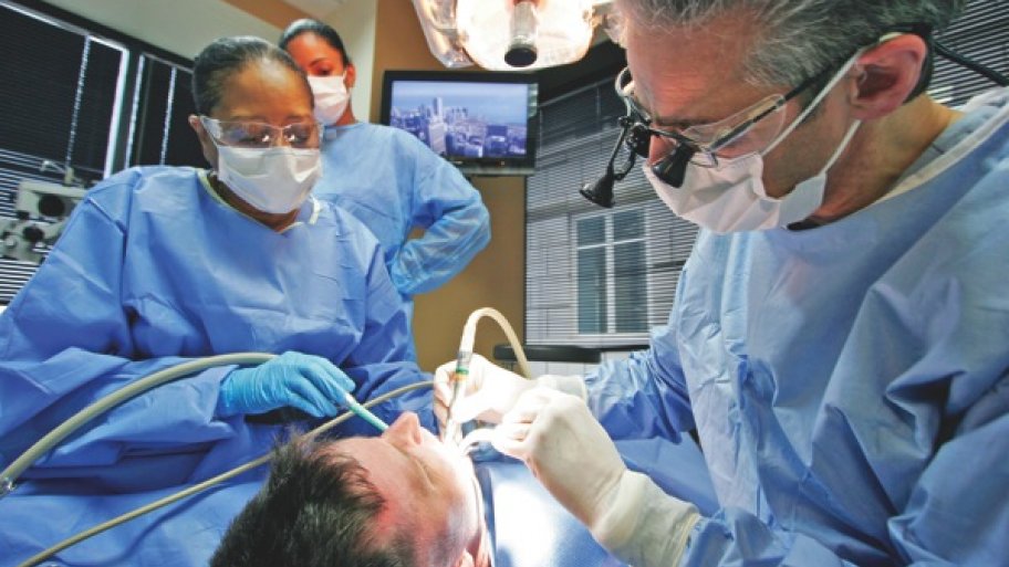 dentist performs a dental implant procedure on a patient.