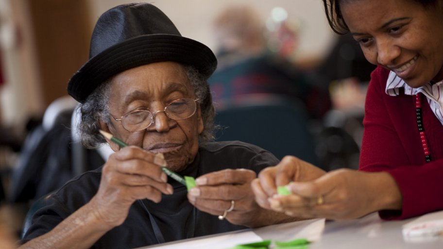 elderly woman using pencil and small piece of paper