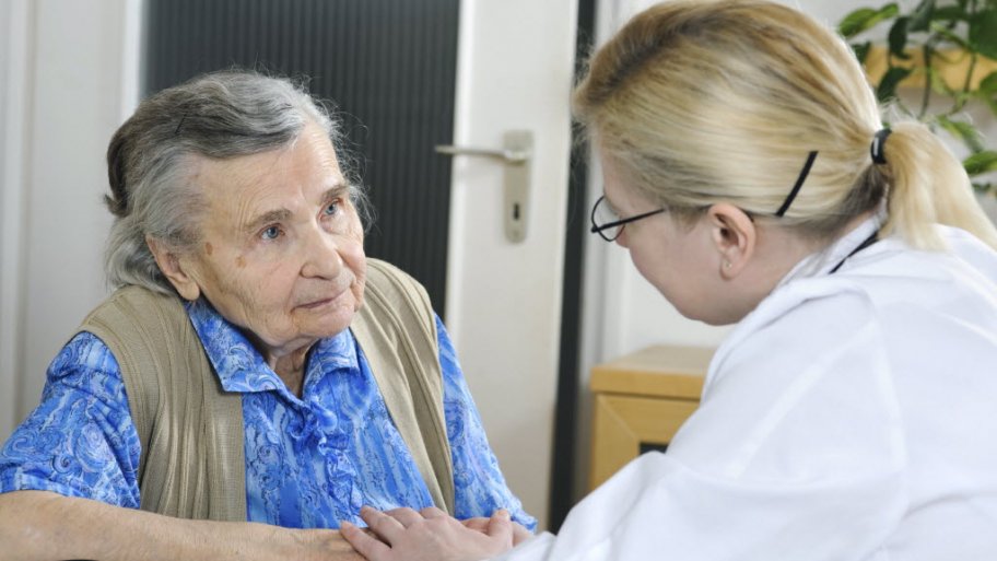 An elderly patient talks with a female doctor