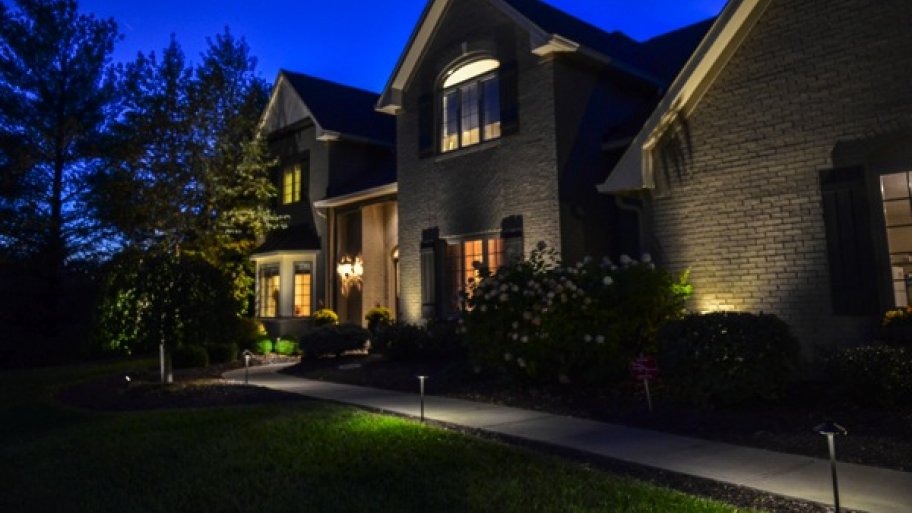 two-story brick home exterior lit up at night